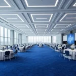 A modern Dubai banquet hall with large windows and a vibrant blue patterned carpet.
