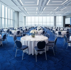 Elegant Dubai ballroom with formal round tables and a vibrant blue patterned carpet.