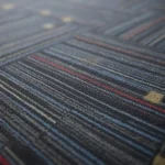 modern office carpet tiles featuring a dark blue base with red and light blue linear stripes.