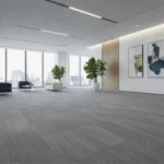 office lobby with grey carpet tiles, large windows, and modern decor.